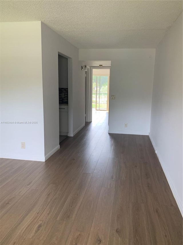 spare room with dark hardwood / wood-style floors and a textured ceiling