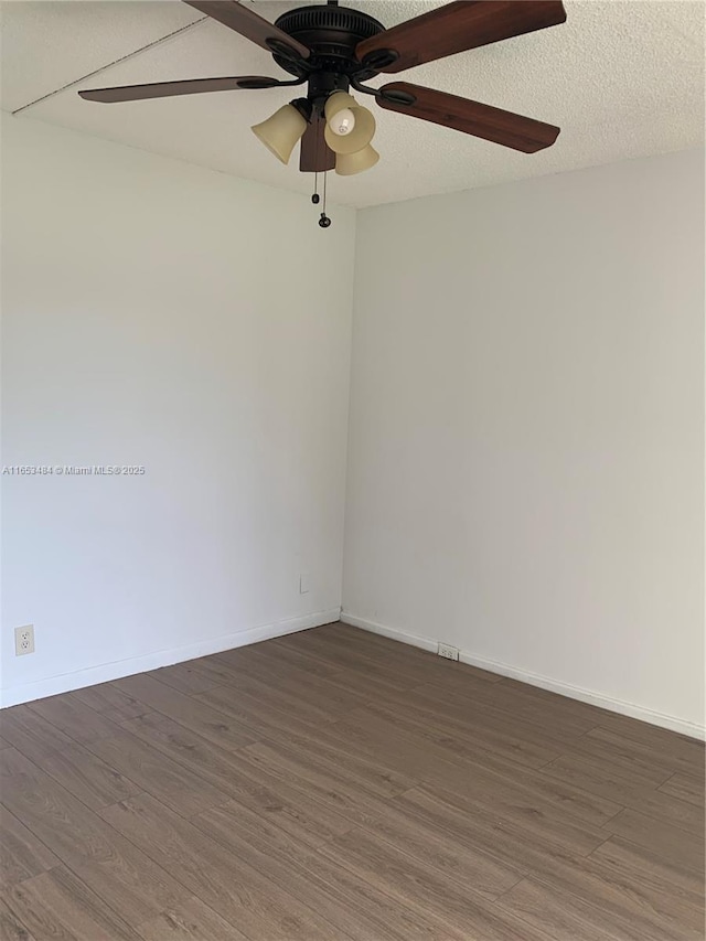 spare room with ceiling fan, dark hardwood / wood-style floors, and a textured ceiling