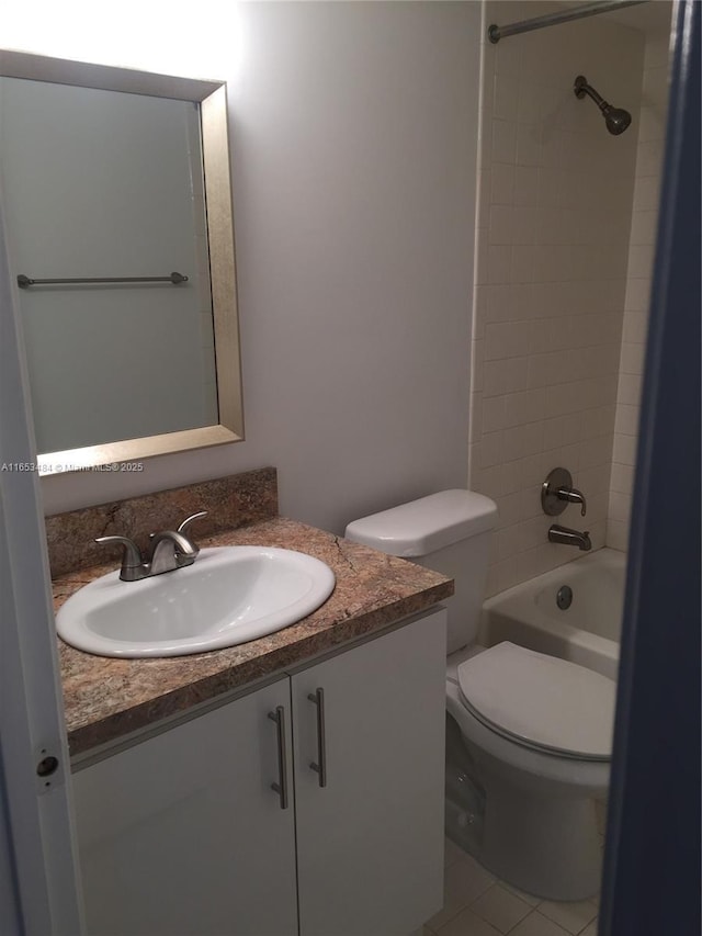 full bathroom featuring vanity, tiled shower / bath combo, tile patterned floors, and toilet