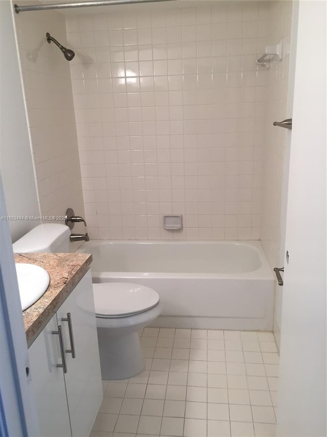 full bathroom featuring vanity, tiled shower / bath combo, tile patterned floors, and toilet