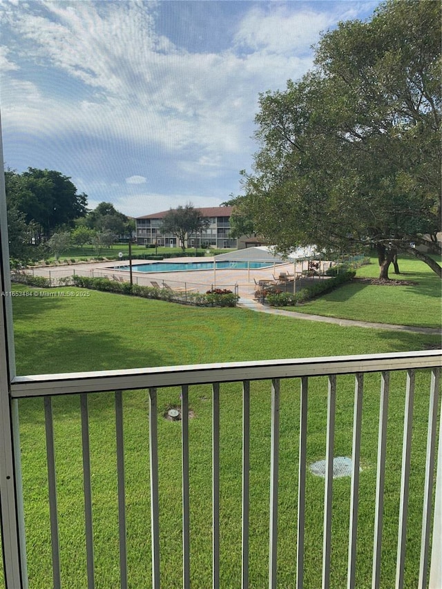 surrounding community featuring a pool and a lawn