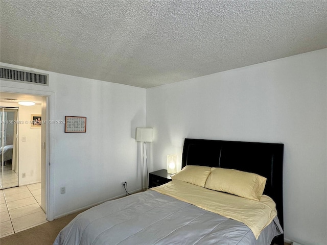 bedroom with light tile patterned flooring and a textured ceiling