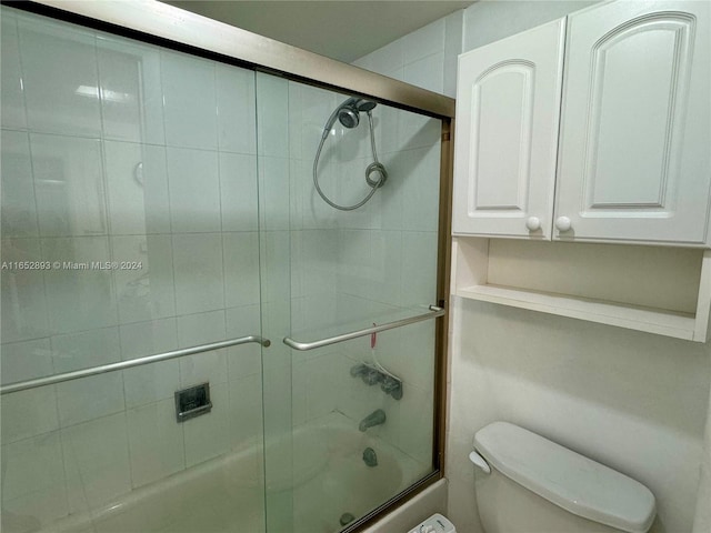 bathroom with toilet and enclosed tub / shower combo