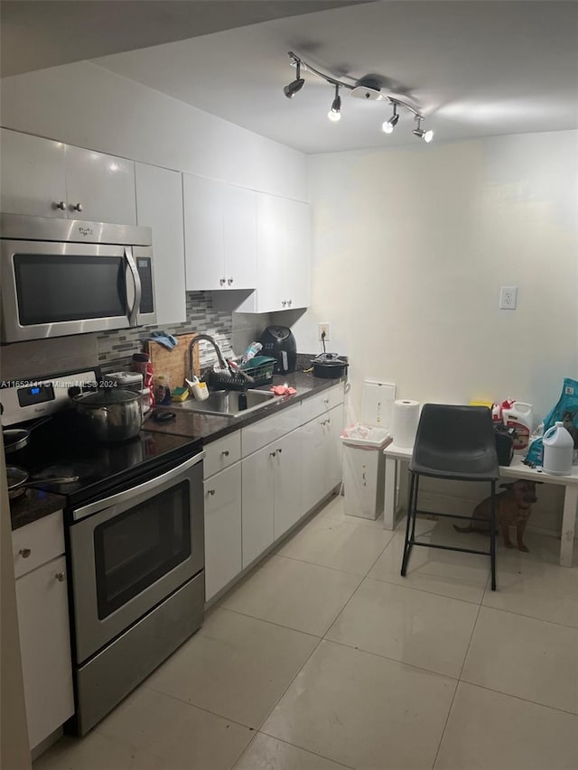 kitchen featuring tasteful backsplash, stainless steel appliances, white cabinetry, and sink