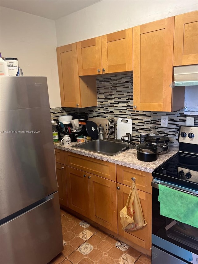 kitchen with stainless steel appliances, sink, tasteful backsplash, and tile patterned floors