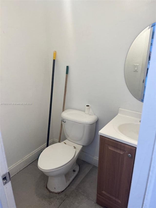 bathroom featuring vanity, toilet, and concrete flooring