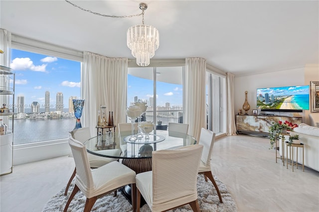 dining room with an inviting chandelier and a water view