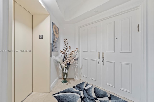 foyer with elevator and light tile patterned floors