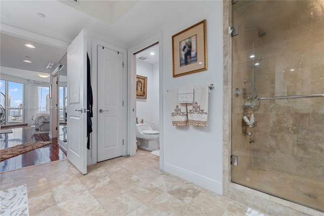 bathroom with a shower with door and toilet