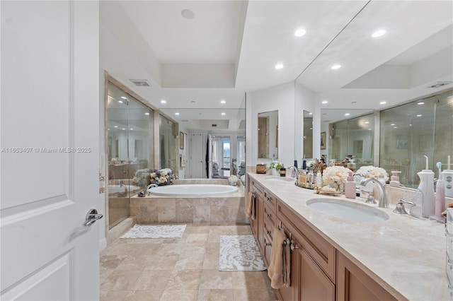 bathroom with vanity and shower with separate bathtub