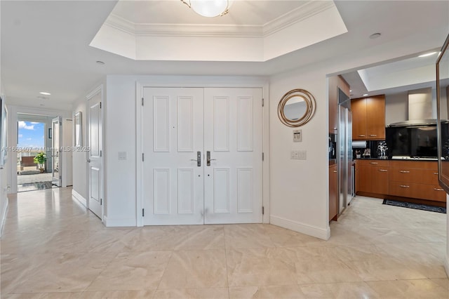 foyer featuring ornamental molding and a tray ceiling