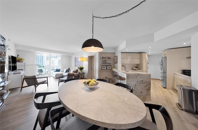 dining area with sink and light hardwood / wood-style flooring