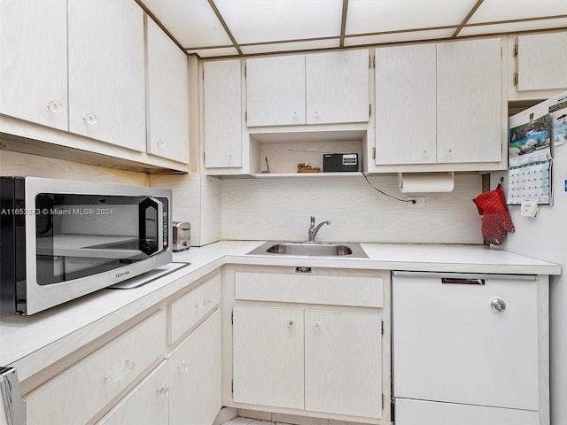 kitchen with dishwasher, sink, and a drop ceiling