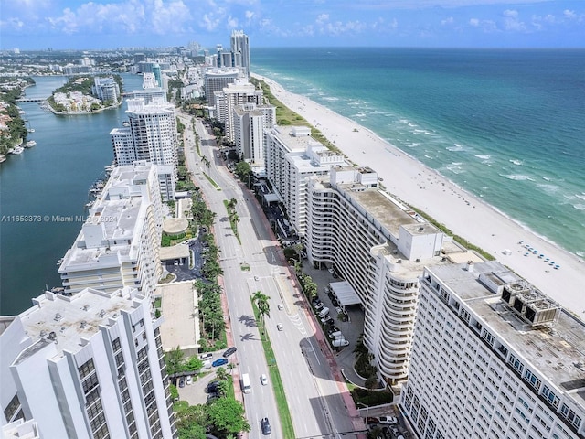 birds eye view of property with a water view and a beach view