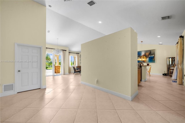 tiled empty room featuring high vaulted ceiling