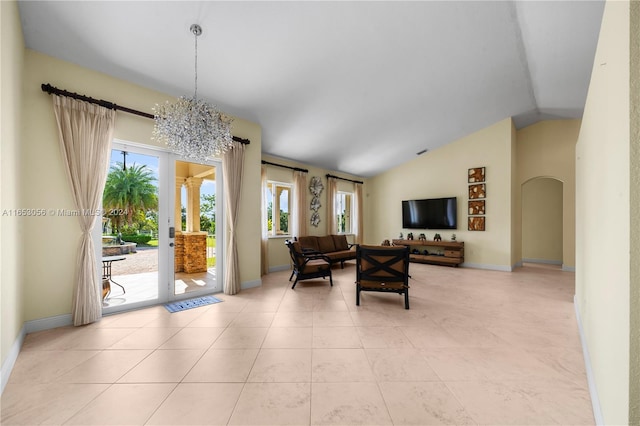 living room with light tile patterned floors, lofted ceiling, a healthy amount of sunlight, and an inviting chandelier