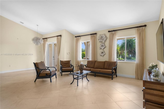 tiled living room with vaulted ceiling, a notable chandelier, and a healthy amount of sunlight