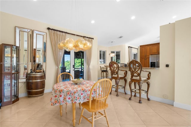 tiled dining room with an inviting chandelier and french doors