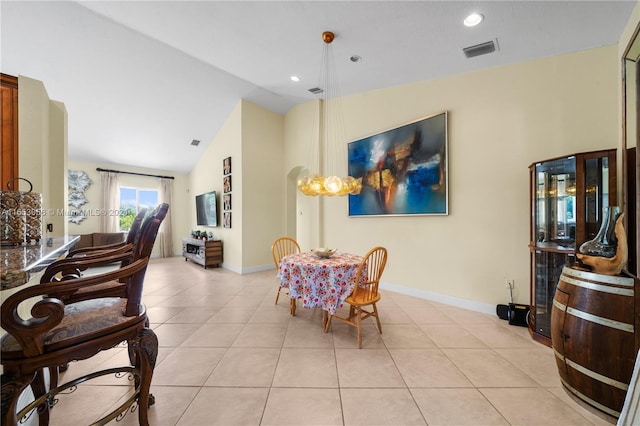 tiled dining room featuring vaulted ceiling