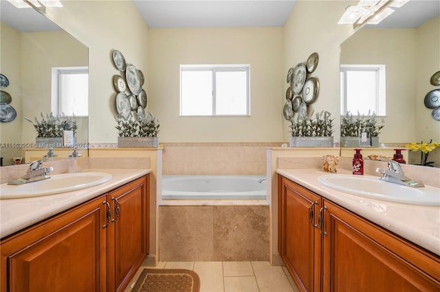 bathroom with a wealth of natural light, vanity, tiled tub, and tile patterned flooring