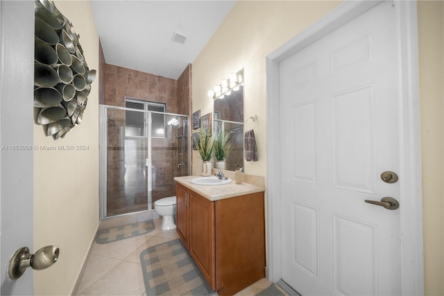 bathroom with vanity, toilet, an enclosed shower, and tile patterned flooring