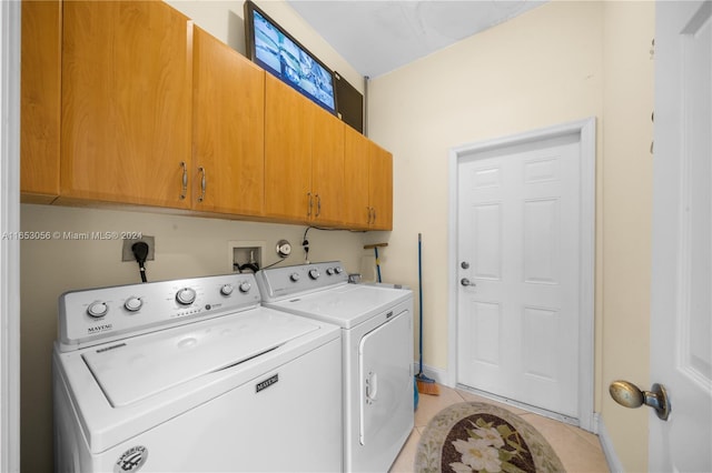 washroom featuring washer and dryer, cabinets, and light tile patterned flooring