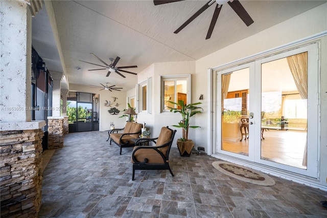 sunroom featuring ceiling fan and french doors