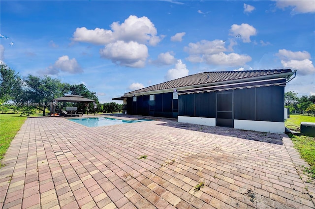 view of pool featuring a sunroom, a patio, and a gazebo