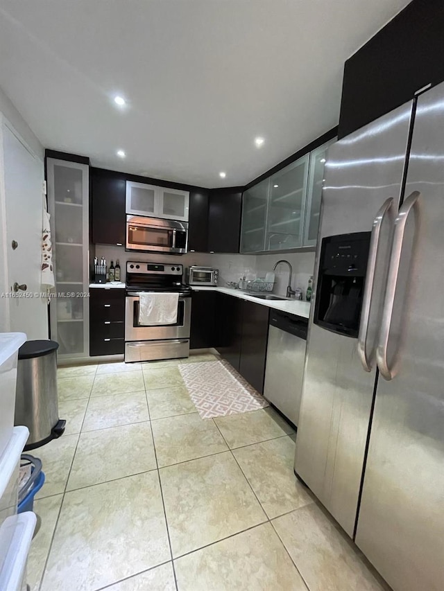 kitchen featuring stainless steel appliances, sink, and light tile patterned flooring