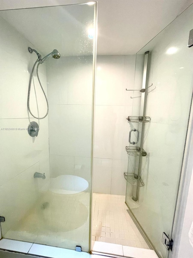 bathroom with tiled shower and tile patterned floors