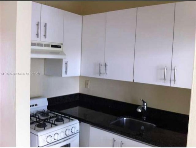 kitchen featuring white gas range, white cabinetry, and sink