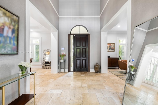 entryway with a wealth of natural light and crown molding