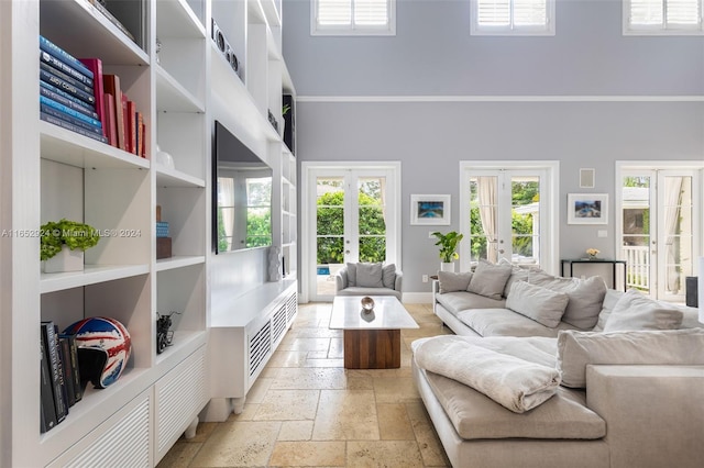 living room with french doors and a towering ceiling