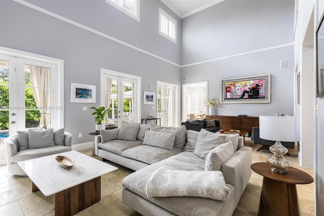 living room featuring french doors, a towering ceiling, and a wealth of natural light