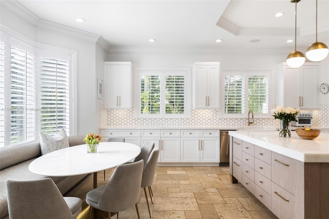 kitchen with decorative light fixtures, plenty of natural light, white cabinetry, and backsplash