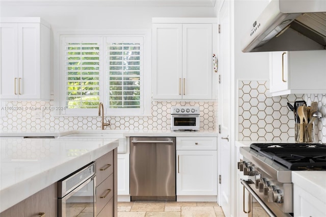 kitchen with white cabinets, appliances with stainless steel finishes, and ventilation hood