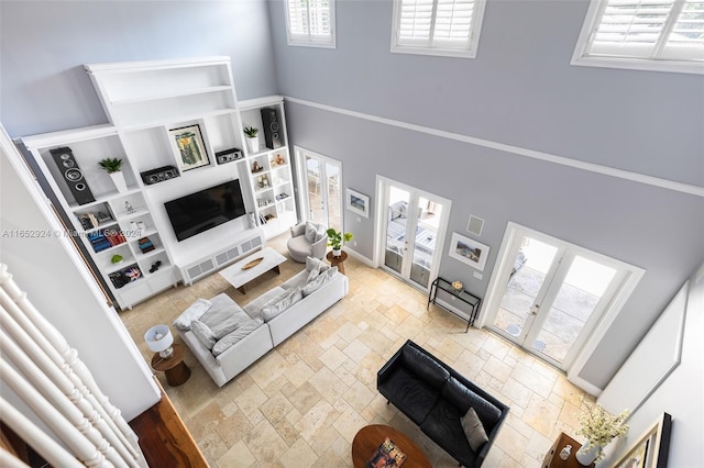 living room featuring french doors, a towering ceiling, and a wealth of natural light