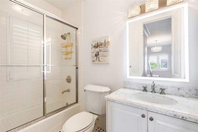 full bathroom with vanity, toilet, and combined bath / shower with glass door