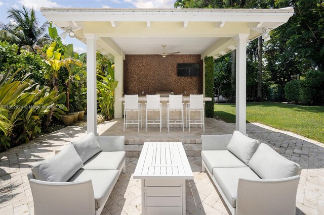 view of patio featuring an outdoor living space, ceiling fan, and a bar