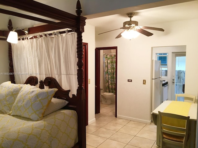 tiled bedroom with white refrigerator, ensuite bathroom, and ceiling fan