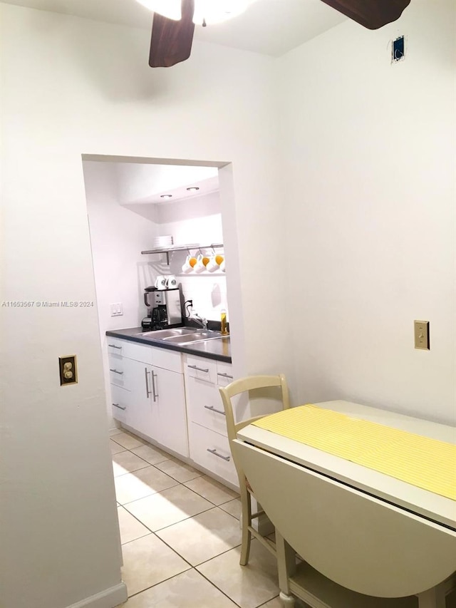 kitchen with ceiling fan, sink, light tile patterned floors, and white cabinets