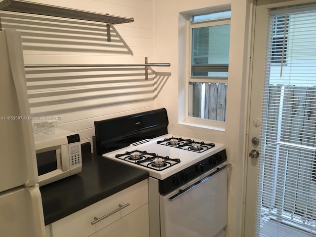 kitchen with white appliances and white cabinets