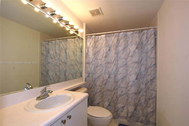 bathroom with walk in shower, toilet, and vanity