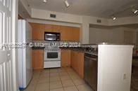 kitchen with black appliances, kitchen peninsula, and light tile patterned floors