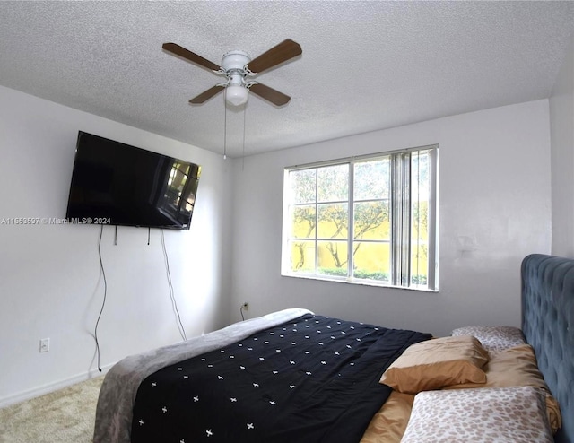 carpeted bedroom with a textured ceiling and ceiling fan