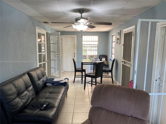 living room featuring ceiling fan, light tile patterned floors, french doors, and a drop ceiling