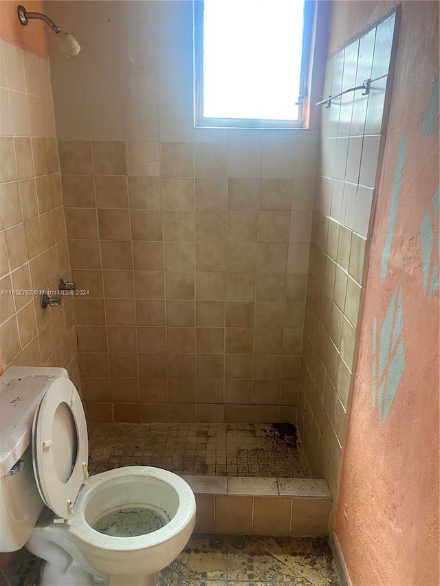 bathroom with tiled shower and toilet