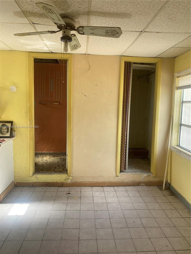 empty room featuring a paneled ceiling and ceiling fan