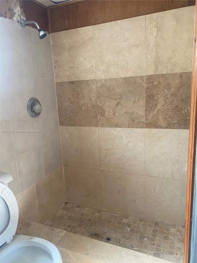 bathroom featuring toilet and a tile shower