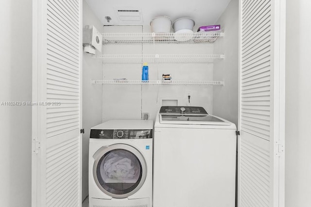 clothes washing area with separate washer and dryer